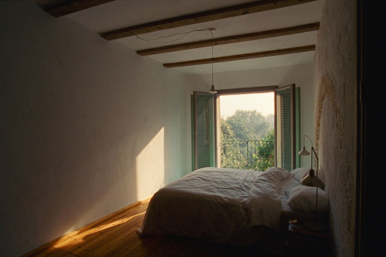 Chambre lumineuse aux poutres apparentes, photographie d’ambiance